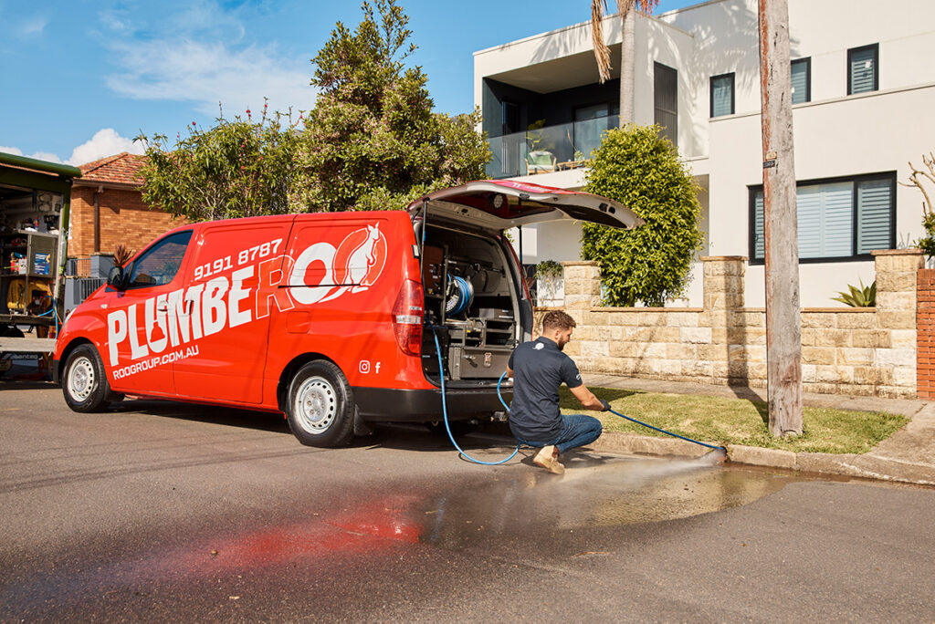 plumber clearing blocked drain